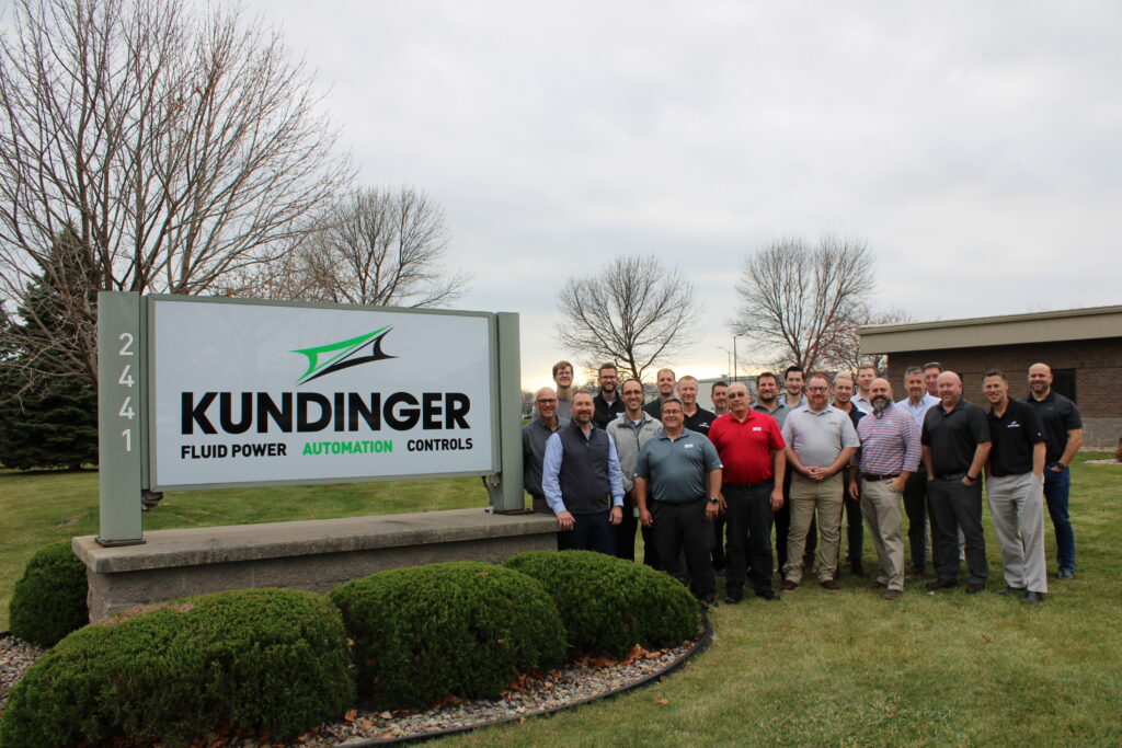 Members of the Kundinger and SEW teams pose outside of the Kundinger headquarters building in Neenah, Wisconsin.